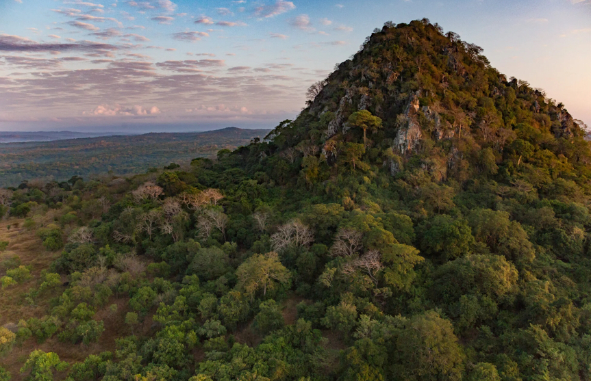 A rocky wooded hill rising above the surrounding landscape